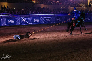 Image of Michael Gascon towing a man with his horse during a performance in the Gascon Horsemanship Never Give Up Tour, showcasing a powerful and dynamic equestrian feat that captivates the audience.