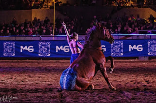 Image of Cat Zimmerman showcasing her impressive Mustang Liberty Act during the Gascon Horsemanship Never Give Up Tour, demonstrating a strong bond and harmony between her and the Mustang, captivating the audience with their performance.