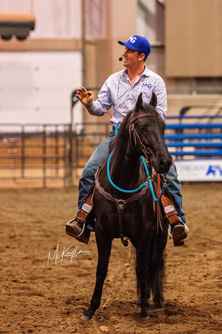 Michael Gascon riding a horse during a Gascon horsemanship clinic session, leading by example and creating a positive equestrian experience.