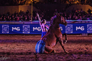 Image of Cat Zimmerman showcasing her impressive Mustang Liberty Act during the Gascon Horsemanship Never Give Up Tour, demonstrating a strong bond and harmony between her and the Mustang, captivating the audience with their performance.