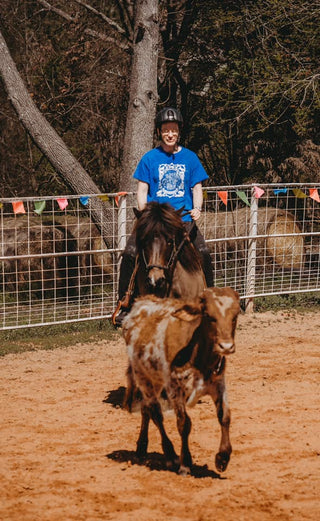 A customer building their confidence while working with cows during a Horse Help retreat, emphasizing personal growth and overcoming challenges.