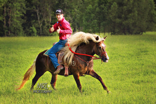 Michael Gascon demonstrating exceptional horsemanship skills by striking a pose while riding a horse in reverse. A captivating display of control, communication, and a strong bond between rider and horse.
