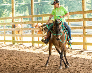 Image of a retreat participant diligently working on her horsemanship skills with her horse in the arena, showcasing dedication and focused learning during the retreat experience.