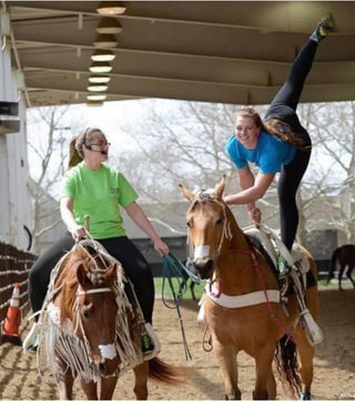 Image of Kelsey Gascon confidently showcasing a demo during a Trick Riding 101 Clinic, demonstrating skill and expertise in the art of trick riding to educate and entertain participants.