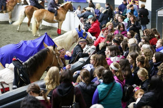 Image of Kelsey Gascon, along with other Trixie Chicks Trick Riders, engaging in autograph signing, creating a moment of connection and appreciation with the audience.