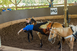 Image of Kelsey Gascon confidently showcasing a demo during a Trick Riding 101 Clinic, demonstrating skill and expertise in the art of trick riding to educate and entertain participants.