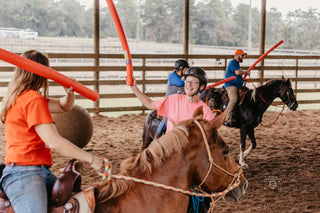 Image of retreat participants joyfully engaging in jousting activities in the arena, creating a lively and spirited atmosphere during the retreat experience.
