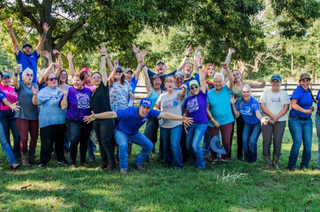 Michael Gascon posing with a group of clients during a Horse Help retreat, fostering community and learning in an equestrian setting.
