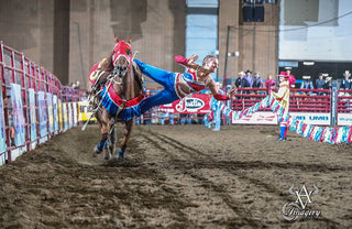 Image of Shelby Epperson performing the Stroud Layout during a Trixie Tricks Riders performance, showcasing exceptional equestrian skills and a captivating Stroud Layout maneuver.