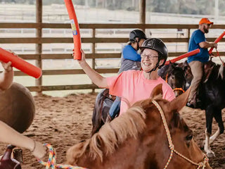 Image of retreat participants joyfully engaging in jousting activities in the arena, creating a lively and spirited atmosphere during the retreat experience.