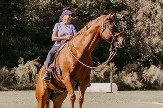Image of a retreat participant confidently guiding her horse through an obstacle, demonstrating skill and partnership during the retreat activities.