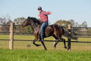 Michael Gascon confidently riding a horse, showcasing his expertise and connection with equine partners.