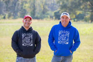 MG staff members proudly displaying MG caps and the Never Give Up Tour hoodies.